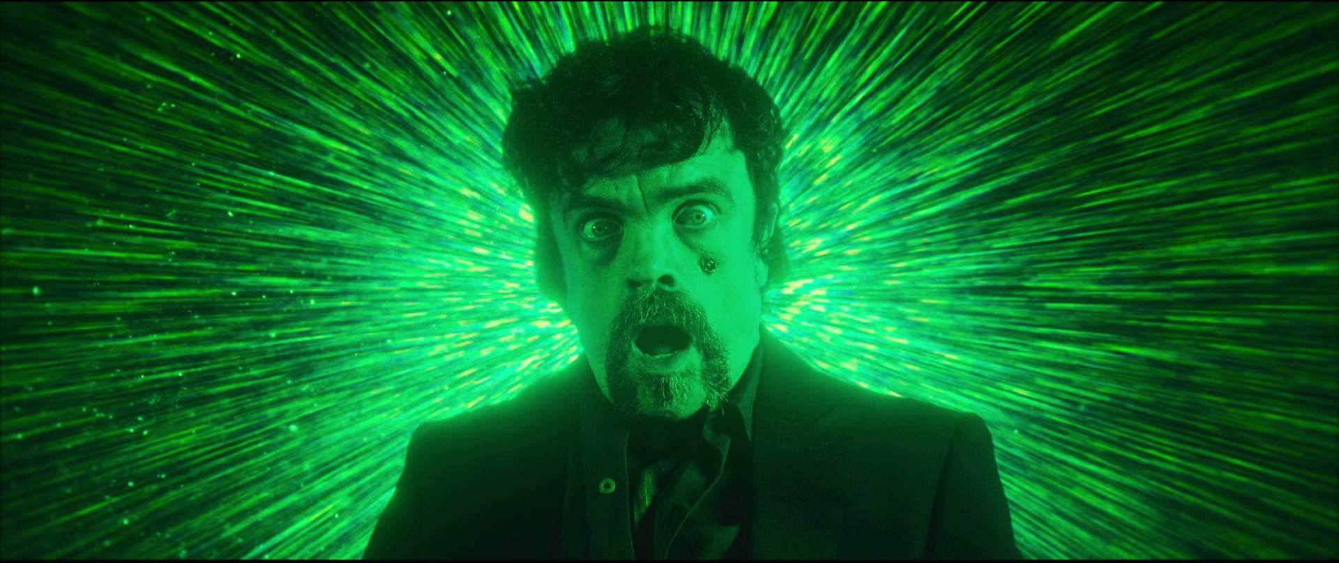 Still from The Toxic Avenger: Peter Dinklage wide-eyed against a burst of green light