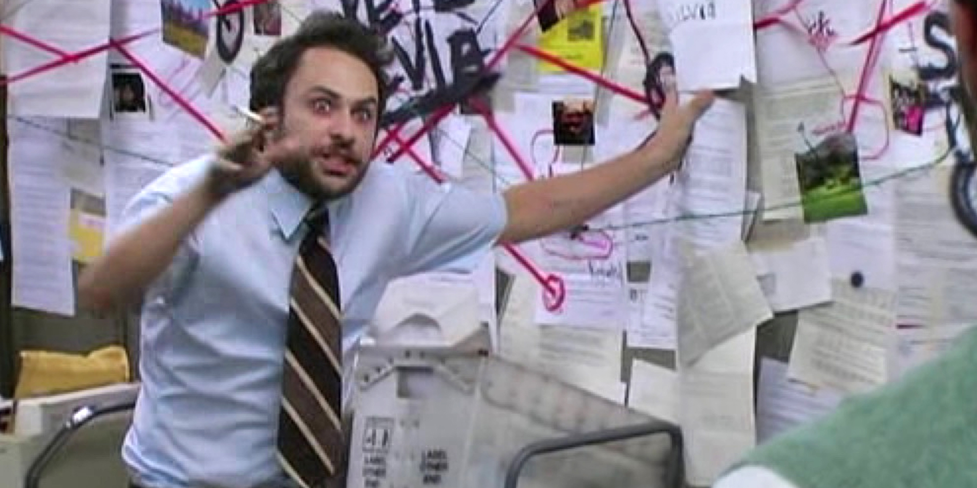 Charlie Day as Charlie Kelly in It's Always Sunny in Philadelphia, explaining a conspiracy board of papers and red string